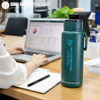 Bình giữ nhiệt GN-BN08 màu xanh lục bảo dung tích 1.2L đặt cạnh máy tính làm việc tại văn phòng