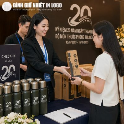 Ban tổ chức trao tặng bình giữ nhiệt in logo kỷ niệm 20 năm thành lập cho khách mời tại bàn check-in