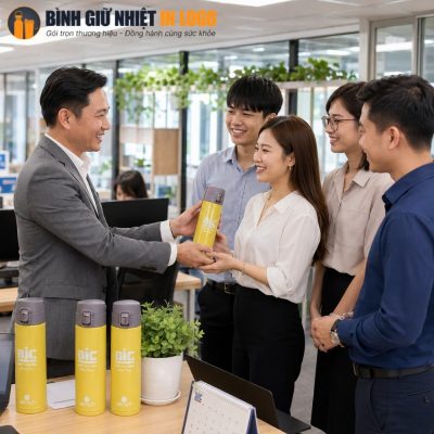 Đại diện doanh nghiệp trao tặng bình giữ nhiệt Elmich in logo cho nhân viên văn phòng tại nơi làm việc