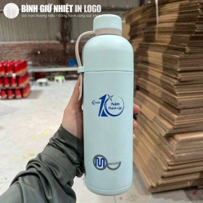 Thực tế cầm nắm chiếc bình giữ nhiệt Lock&Lock 490ml màu xanh mint dịu nhẹ tại xưởng sản xuất
