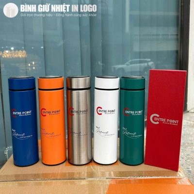 Năm phiên bản màu sắc của bình giữ nhiệt gồm xanh dương, cam, bạc, trắng và xanh lá đặt cạnh hộp quà tặng màu đỏ