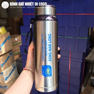 Cầm trên tay bình giữ nhiệt GN-BN17 in logo xanh nổi bật trên nền inox