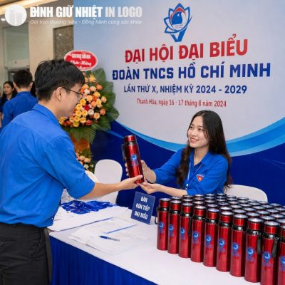 Các đại biểu hào hứng nhận bình giữ nhiệt quà tặng màu đỏ tại bàn đón tiếp Đại hội Đoàn