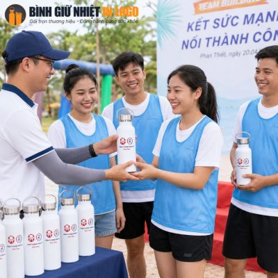 Thành viên đội nhóm hào hứng nhận bình nước GN-BN11 trong chương trình team building bãi biển