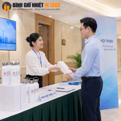 Nhân viên lễ tân trao tận tay hộp quà tặng bình nước GN-BN11 cho khách hàng tại sự kiện doanh nghiệp