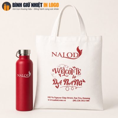 Bình giữ nhiệt đỏ đặt cạnh túi canvas trắng in thông điệp Welcome to Da Nang rõ nét