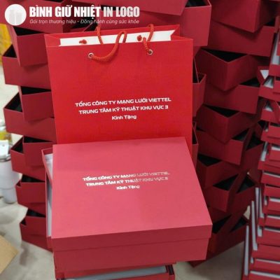 Hộp quà tặng và túi giấy màu đỏ xếp gọn gàng chuẩn bị cho sự kiện tri ân
