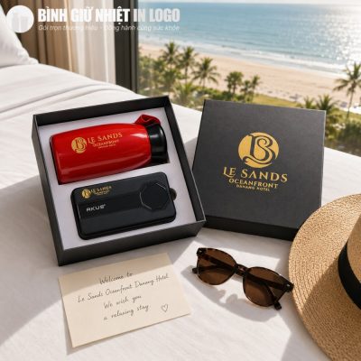 Set quà tặng Le Sands quà tặng Welcome của khách sạn đặt trên giường phòng suite hướng biển cạnh kính râm và mũ cói